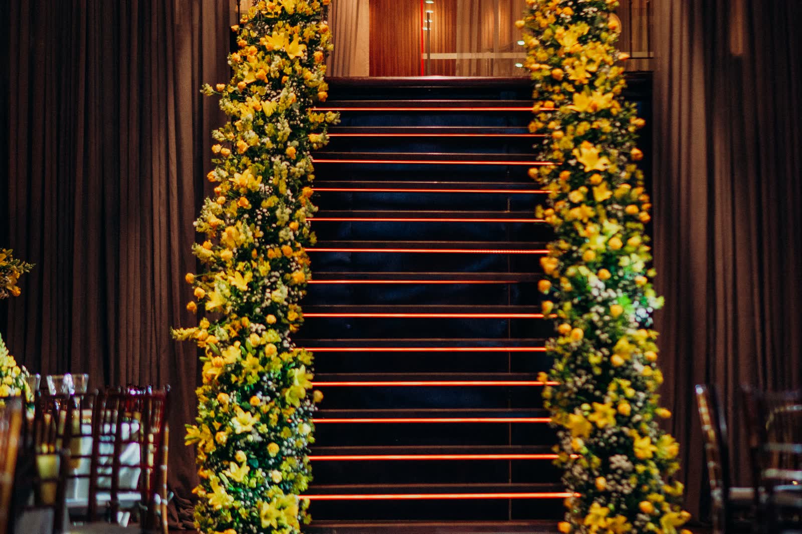 Escadaria emoldurada por colunas de flores amarelas