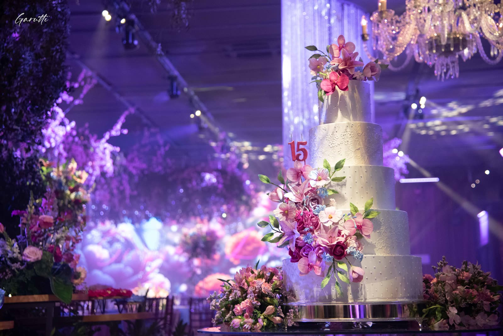 15th birthday cake with flowers in the hall in purple light