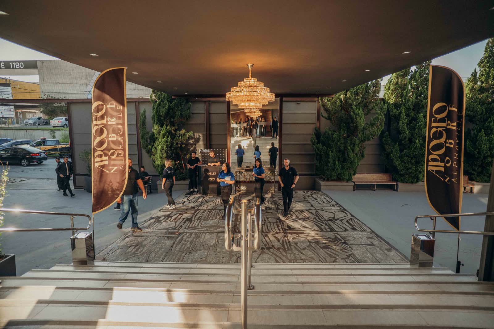 Entrada principal com lustre de cristal e banners da Apogeo