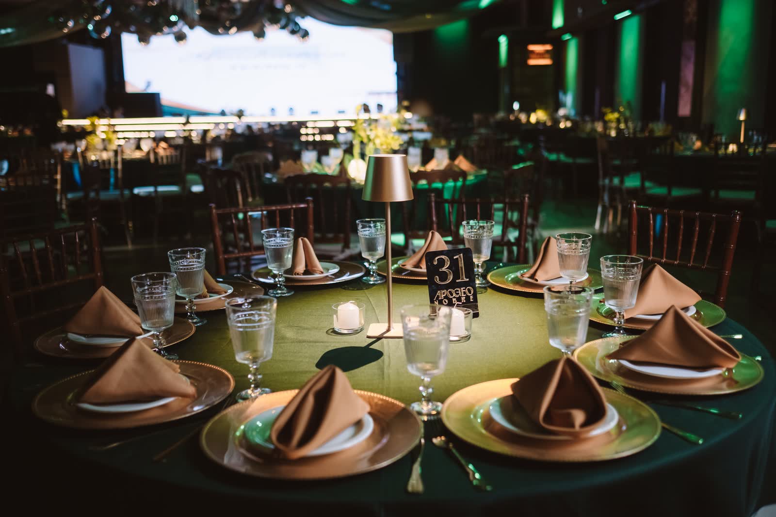 Mesa número 31 do baile, com taças e guardanapos dourados