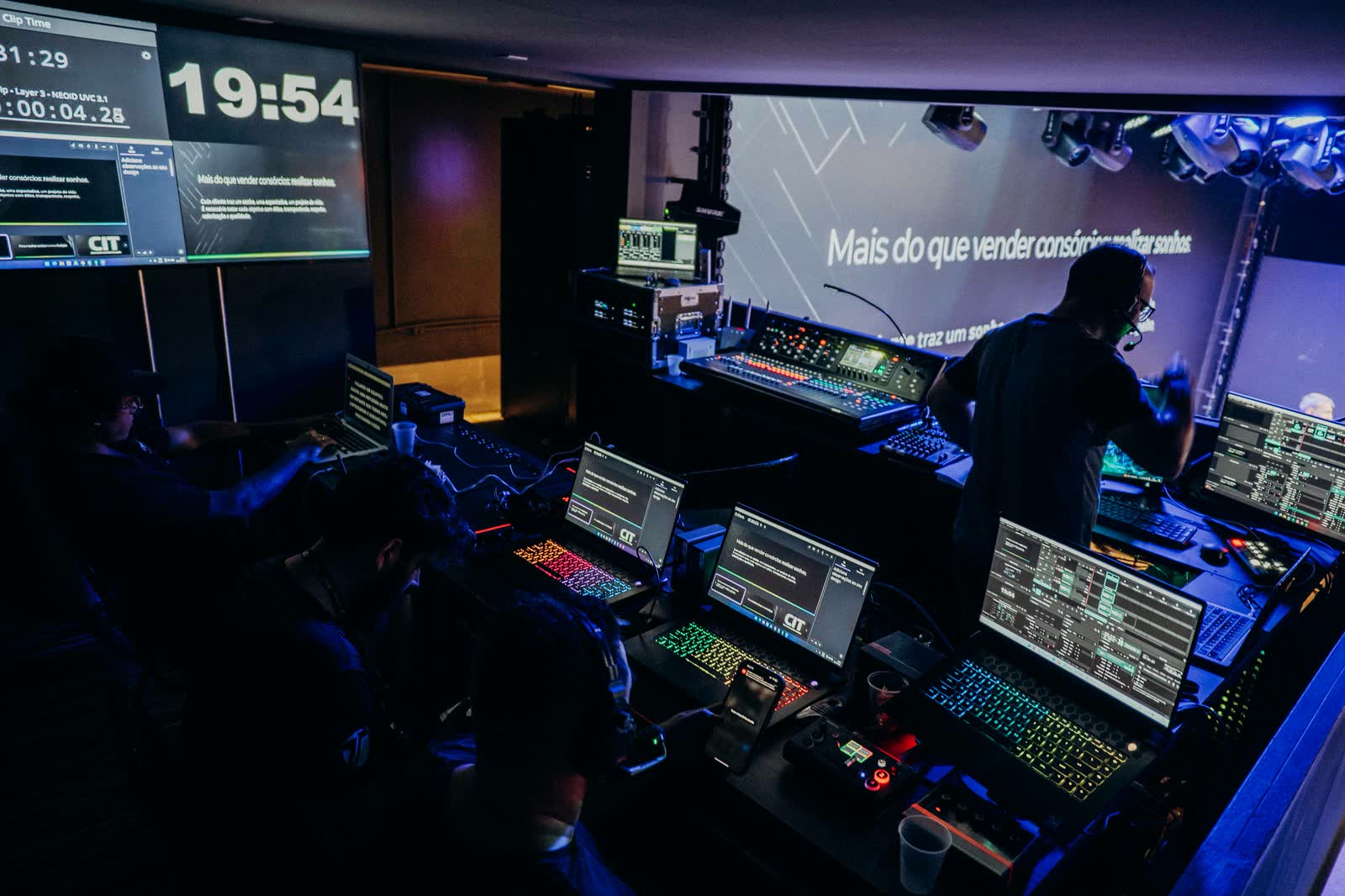 Mesa de controle de áudio e vídeo com operadores durante o evento